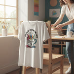 Casual Friday Tees white cotton t-shirt featuring a Fueled by Crayons and Coffee graphic on a chair in a classroom.